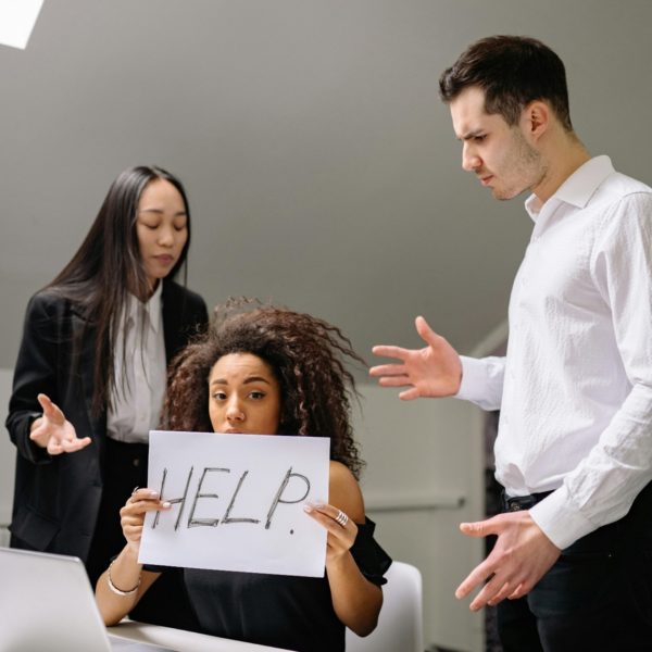 Healthy conflict response strategies for teams. A person holding a sign with other people standing nearby.